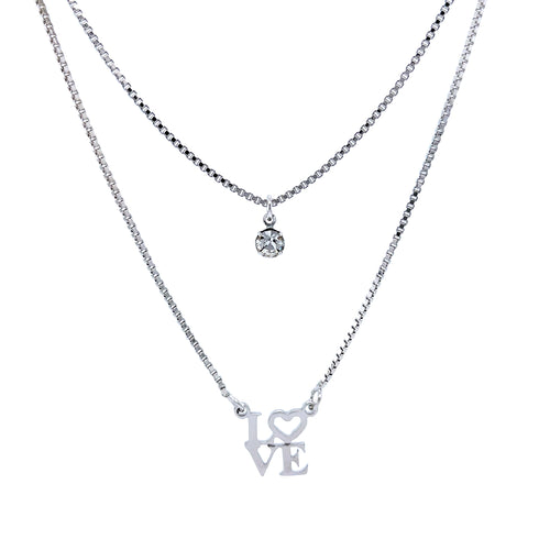 Two delicate silver necklaces on a white background. The top features a small round crystal pendant, while the bottom displays the Platinum Filled Love Pendant Stacked Necklace, showcasing a platinum-filled "LOVE" pendant with the heart replacing "O." Both are lead and nickel-free for safe and stylish wear.